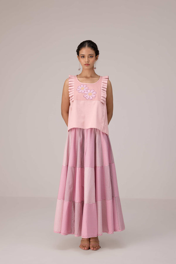 Soft pink sleeveless relaxed fit blouse with pleat details and hand embroidery paired with flared tiered patchwork maxi skirt