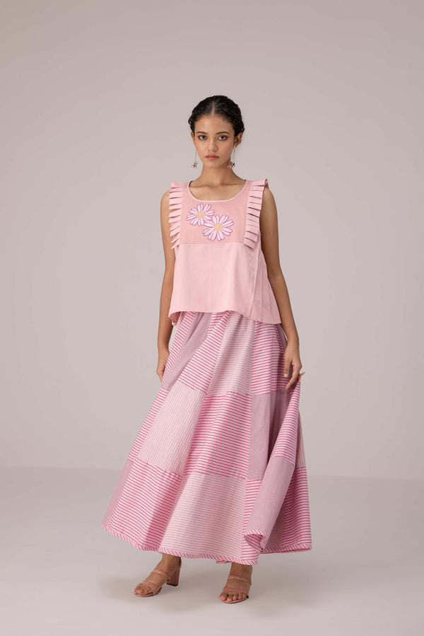 Soft pink sleeveless relaxed fit blouse with pleat details and hand embroidery paired with flared tiered patchwork maxi skirt