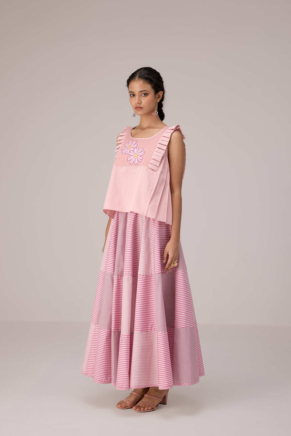 Soft pink sleeveless relaxed fit blouse with pleat details and hand embroidery paired with flared tiered patchwork maxi skirt