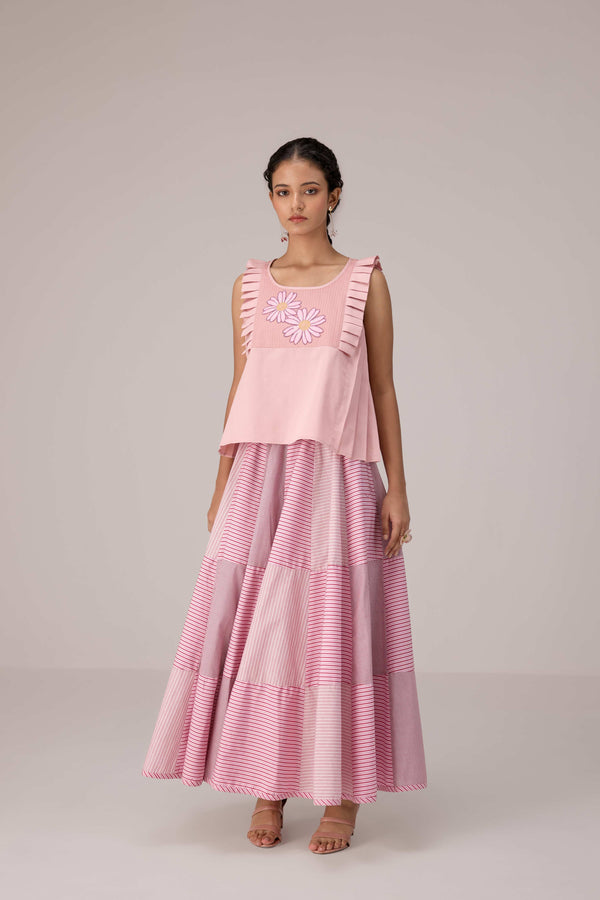 Soft pink sleeveless relaxed fit blouse with pleat details and hand embroidery paired with flared tiered patchwork maxi skirt