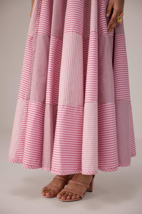 Soft pink sleeveless relaxed fit blouse with pleat details and hand embroidery paired with flared tiered patchwork maxi skirt