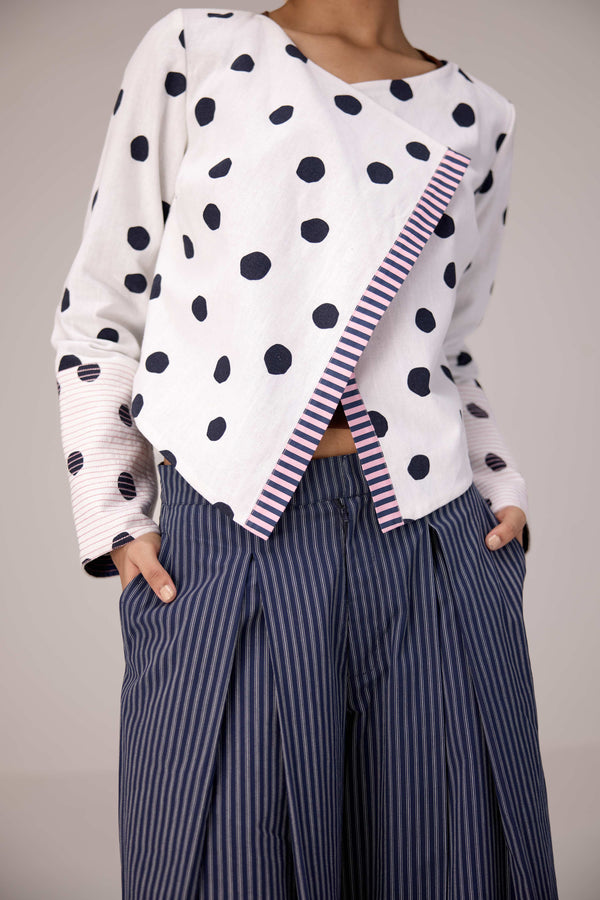 Reversable wrapped jacket in cotton linen paired with pleated striped pants in cotton