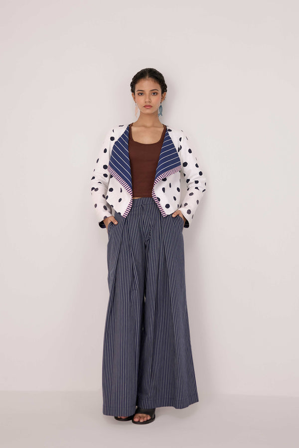 Reversable wrapped jacket in cotton linen paired with pleated striped pants in cotton